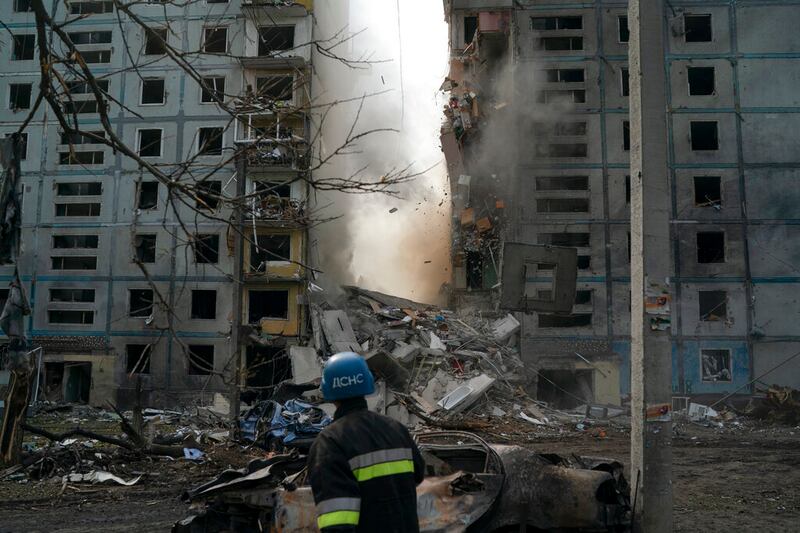 Un bombero mira la caída de un muro de un edificio residencial que sufrió daños graves después de un ataque ruso, el domingo 9 de octubre de 2022, en Zaporiyia, Ucrania.