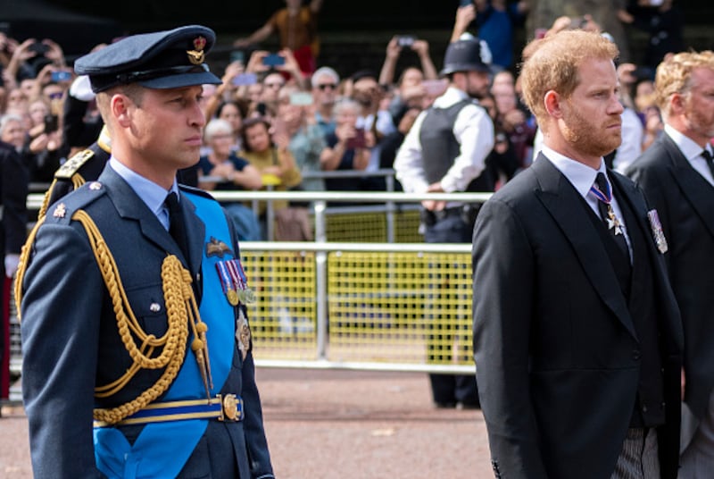 William con su uniforme militar y Harry vestido de civil